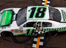 Kyle Busch drives to Victory Lane with the checkered flag after winning the Bashas' Supermarkets 200 at Phoenix International Raceway. Credit: Tom Pennington/Getty Images for NASCAR